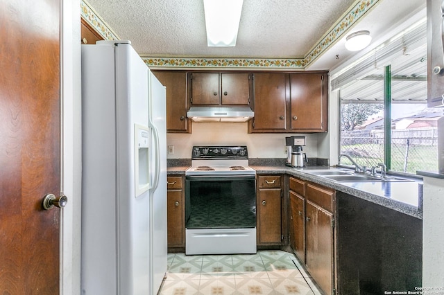 kitchen with electric range, white refrigerator with ice dispenser, dark countertops, a textured ceiling, and under cabinet range hood