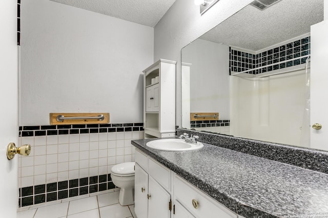 bathroom featuring tile walls, toilet, a textured ceiling, vanity, and tile patterned flooring