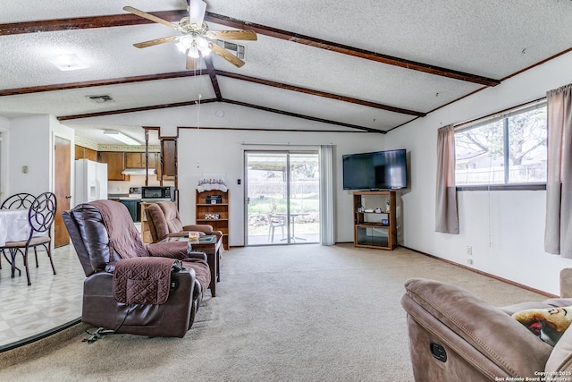 living area with lofted ceiling with beams, a healthy amount of sunlight, visible vents, and light colored carpet