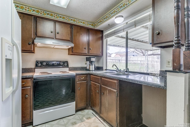 kitchen featuring white refrigerator with ice dispenser, a sink, a textured ceiling, range with electric cooktop, and under cabinet range hood