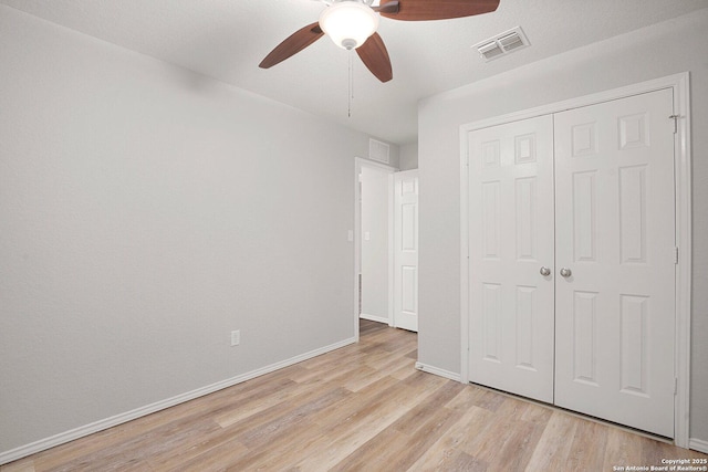 unfurnished bedroom featuring ceiling fan, visible vents, baseboards, a closet, and light wood finished floors