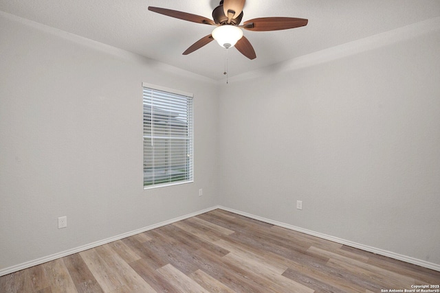 unfurnished room featuring ceiling fan, wood finished floors, and baseboards