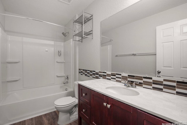 full bath featuring tasteful backsplash, toilet, wood finished floors, bathtub / shower combination, and vanity