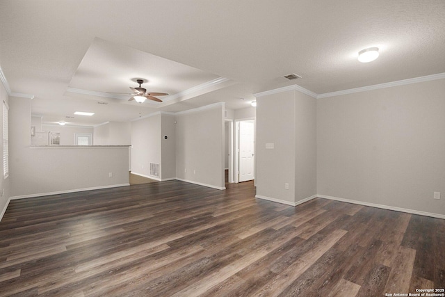 unfurnished room featuring a ceiling fan, crown molding, a tray ceiling, and dark wood-style flooring