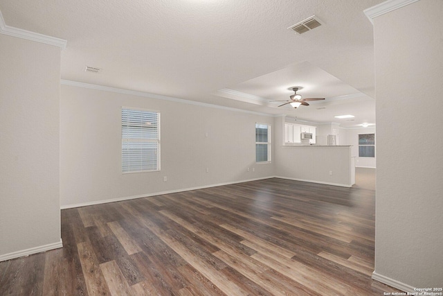 empty room with dark wood-style floors, a wealth of natural light, visible vents, and a ceiling fan