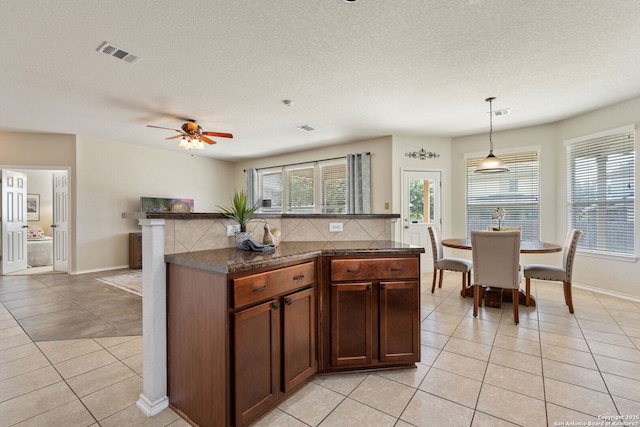 kitchen with light tile patterned floors, visible vents, and a wealth of natural light