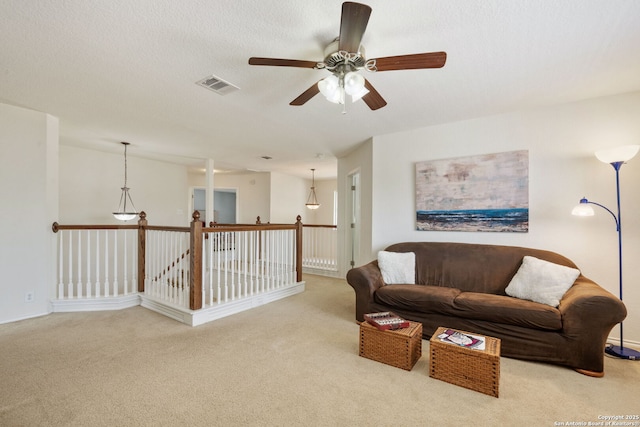 living area featuring visible vents, carpet floors, and a textured ceiling