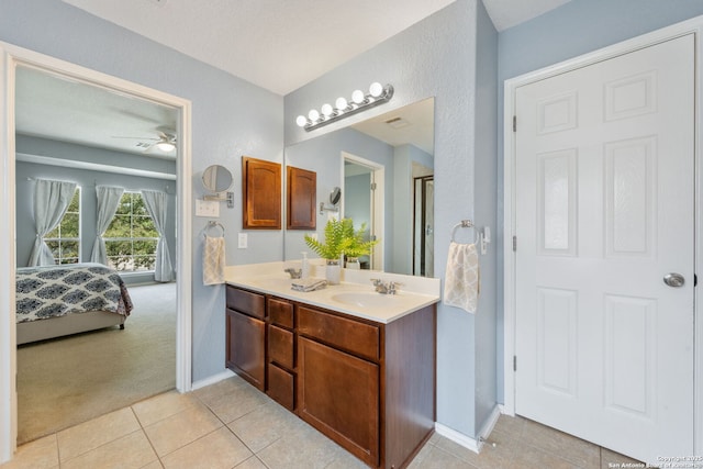 ensuite bathroom with a ceiling fan, ensuite bathroom, a sink, tile patterned flooring, and double vanity