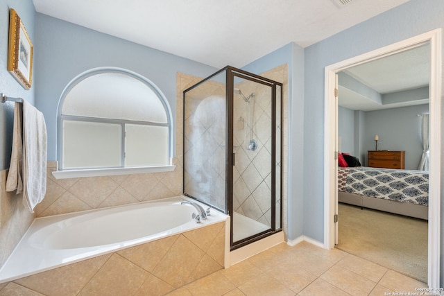 ensuite bathroom with tile patterned floors, connected bathroom, a bath, and a shower stall