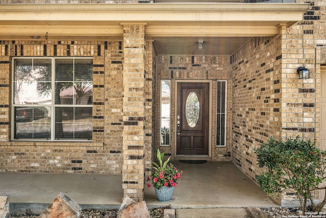 view of exterior entry with brick siding