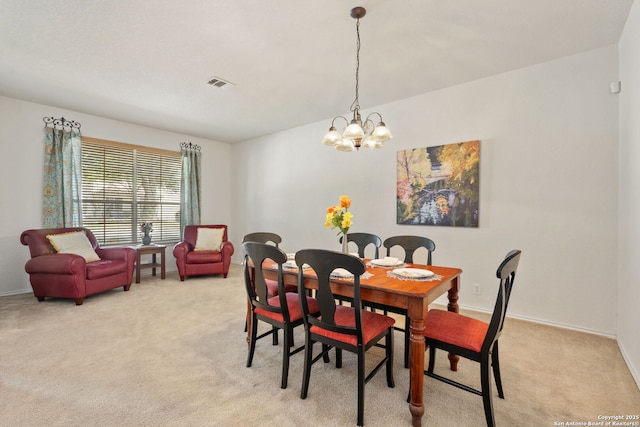 dining room featuring a chandelier, visible vents, light colored carpet, and baseboards