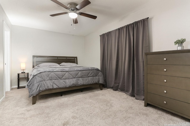 bedroom with ceiling fan, baseboards, and light colored carpet