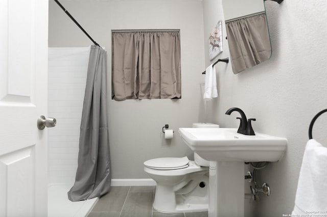 full bathroom with curtained shower, tile patterned flooring, toilet, and baseboards