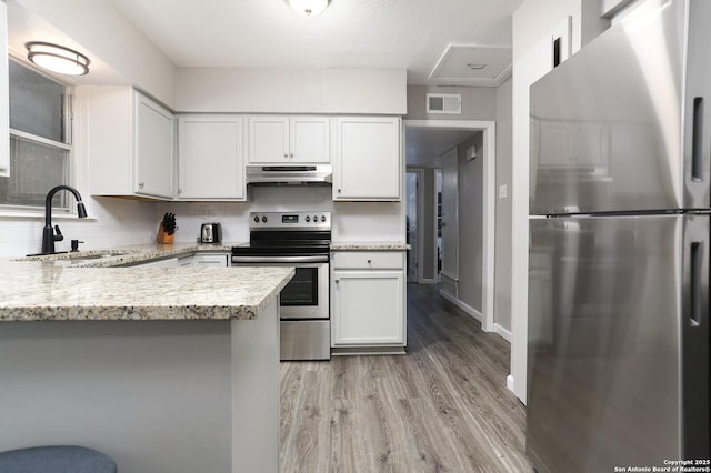 kitchen with tasteful backsplash, appliances with stainless steel finishes, visible vents, and under cabinet range hood