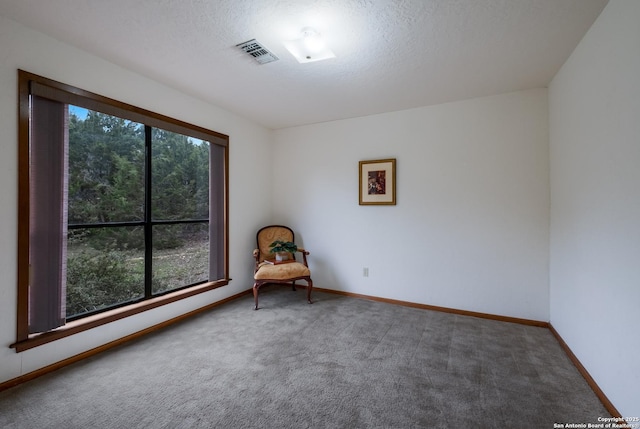 unfurnished room with a healthy amount of sunlight, carpet floors, and visible vents