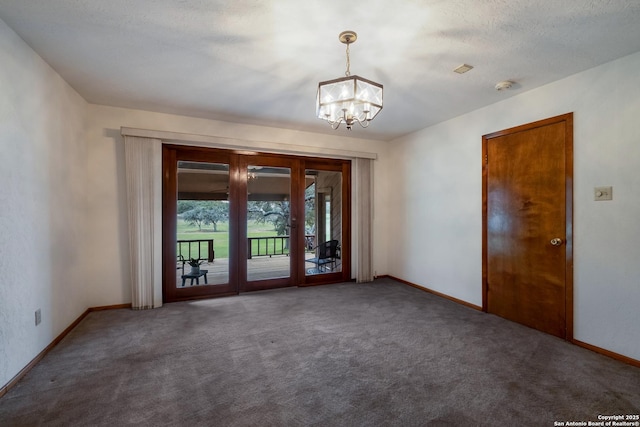 carpeted empty room featuring baseboards, a chandelier, a textured ceiling, and french doors