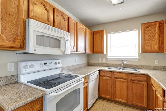 kitchen with white appliances, light countertops, a sink, and light tile patterned floors