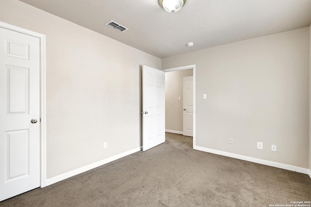 unfurnished bedroom with carpet, visible vents, and baseboards