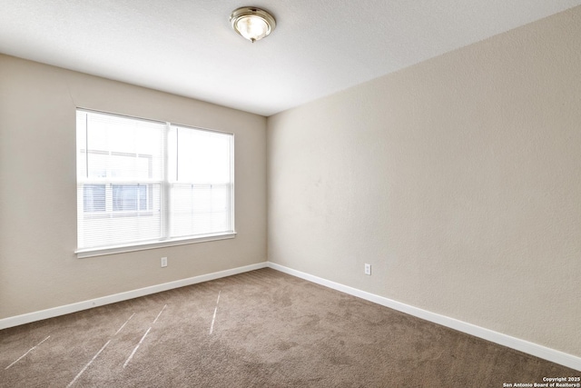 carpeted empty room with baseboards