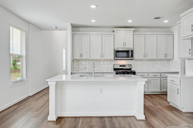 kitchen featuring light countertops, stainless steel appliances, visible vents, and a sink