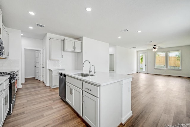kitchen with a ceiling fan, visible vents, appliances with stainless steel finishes, a sink, and light wood-style flooring
