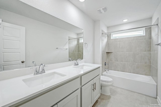 bathroom featuring double vanity, toilet, shower / bath combination, and a sink