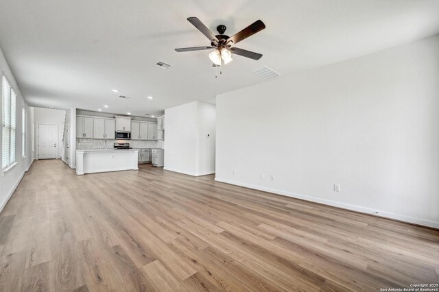 unfurnished living room with recessed lighting, ceiling fan, visible vents, and baseboards