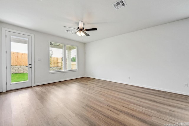 unfurnished room with visible vents, a ceiling fan, baseboards, and wood finished floors