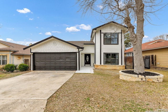 view of front facade featuring a garage, driveway, and fence