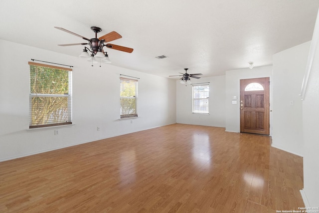 unfurnished living room featuring visible vents, ceiling fan, and light wood-style flooring