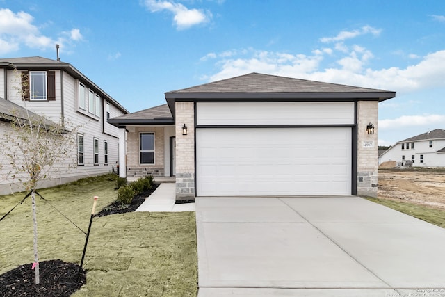 view of front facade featuring driveway, an attached garage, a shingled roof, and brick siding