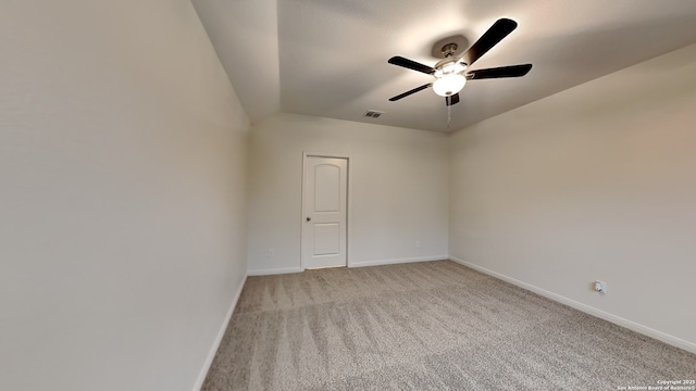 spare room with light colored carpet, ceiling fan, visible vents, and baseboards