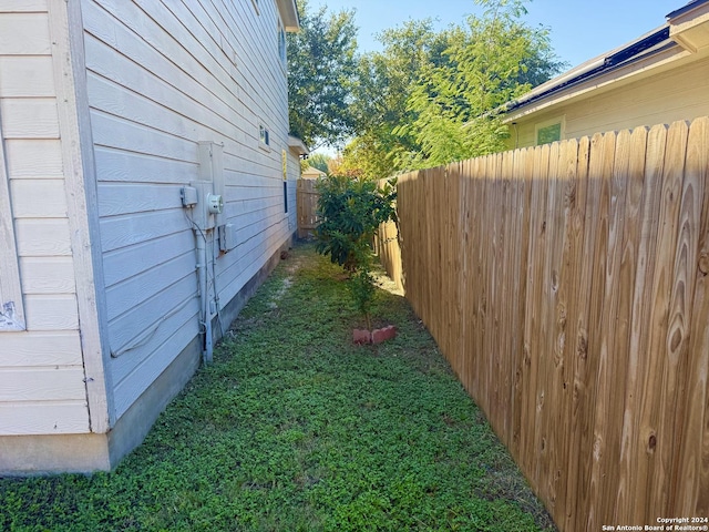 view of side of home featuring a yard and fence