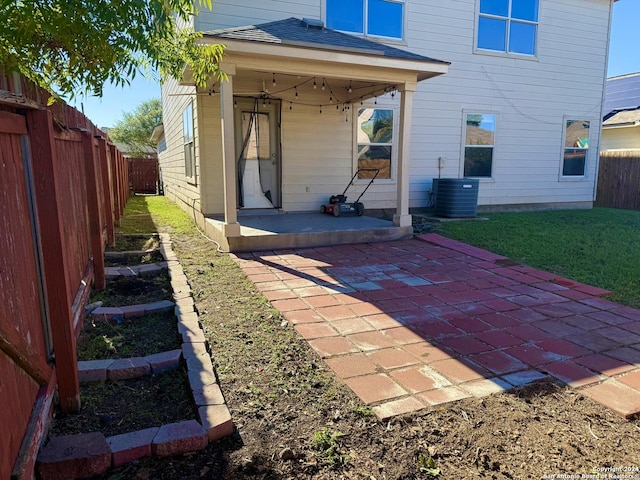 rear view of house featuring a patio area, a fenced backyard, cooling unit, and a yard