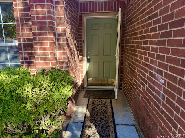 entrance to property featuring brick siding