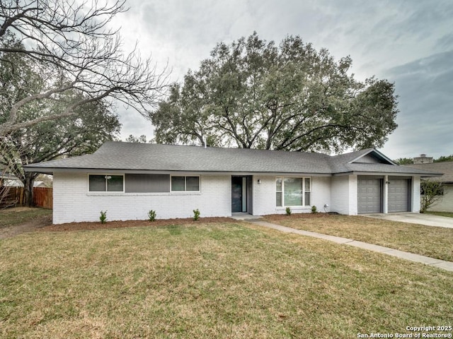 ranch-style home featuring concrete driveway, an attached garage, fence, a front yard, and brick siding