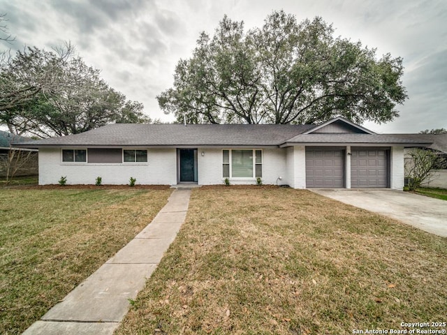 ranch-style home with a garage, a front lawn, concrete driveway, and brick siding