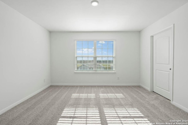 empty room with light carpet and baseboards