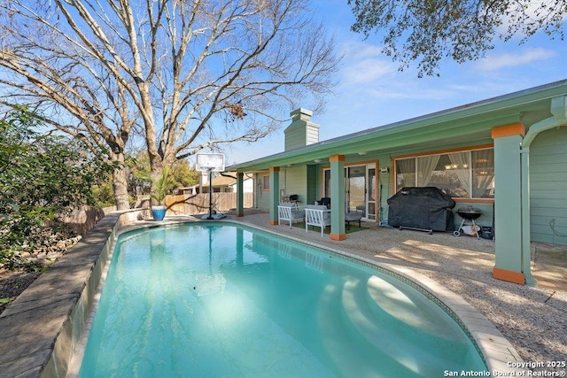 view of swimming pool with a fenced in pool, a patio area, and a grill