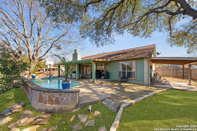 rear view of property featuring a fenced in pool, a fenced backyard, a patio, and a chimney