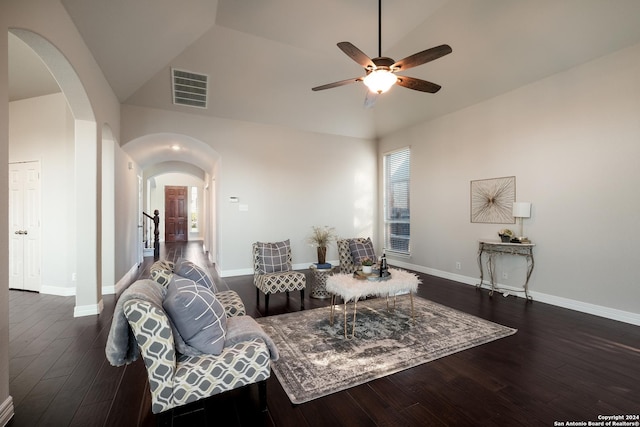 living area featuring arched walkways, visible vents, baseboards, a wealth of natural light, and dark wood-style floors