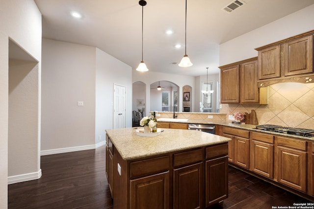 kitchen featuring visible vents, arched walkways, dark wood-style floors, gas stovetop, and stainless steel dishwasher