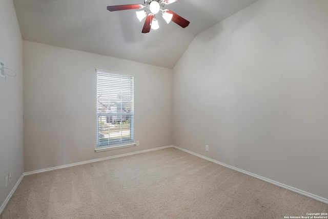 empty room with carpet floors, ceiling fan, baseboards, and vaulted ceiling