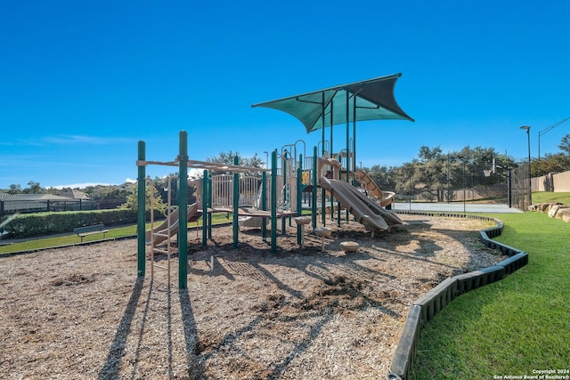 community play area with fence and a lawn