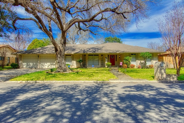 ranch-style house with a garage, driveway, a front lawn, and brick siding