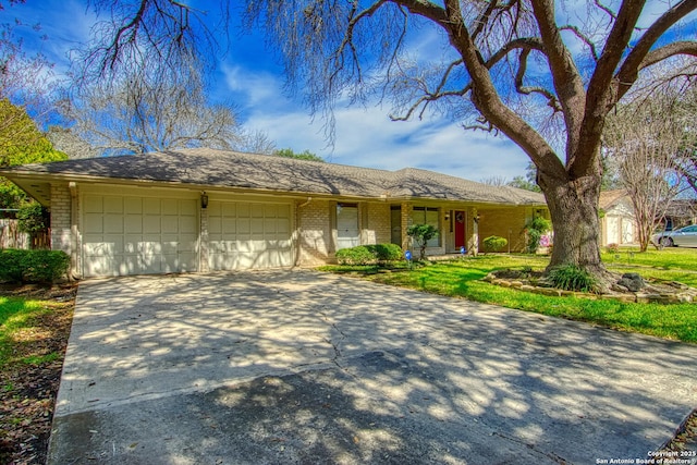 ranch-style home with driveway, brick siding, and an attached garage