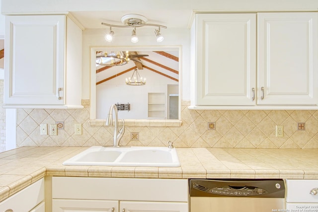 kitchen with vaulted ceiling with beams, decorative backsplash, white cabinets, a sink, and dishwasher