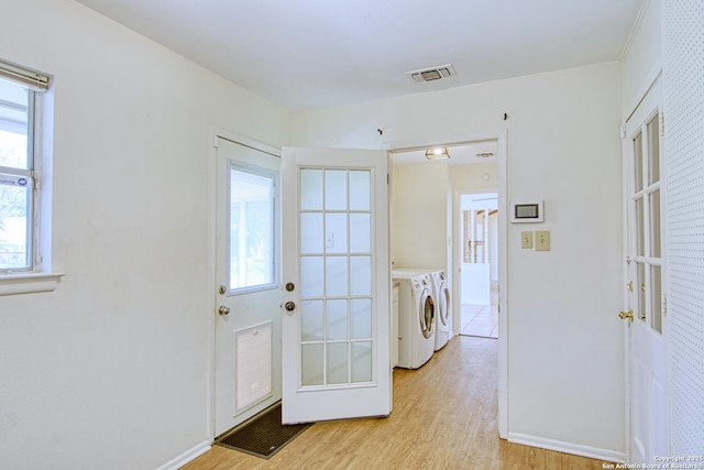 doorway to outside with washer and dryer, french doors, visible vents, and light wood-style flooring