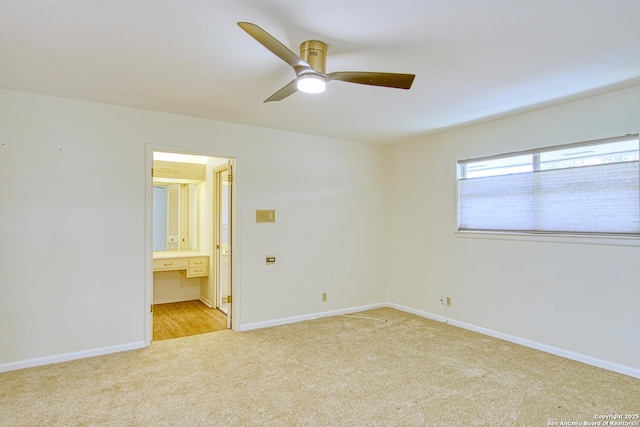 spare room featuring light carpet, a ceiling fan, and baseboards