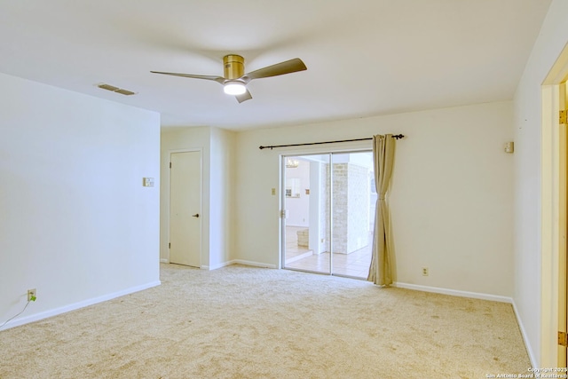 empty room featuring ceiling fan, carpet, visible vents, and baseboards